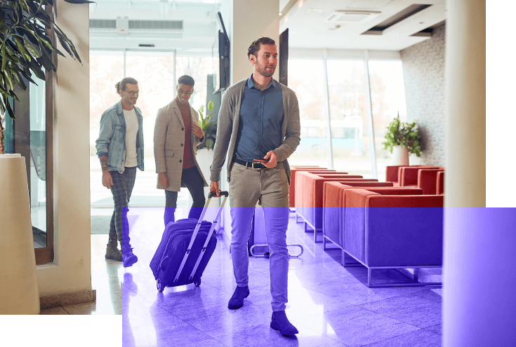 Man carrying luggage in the lobby of a hotel.Business people with luggage