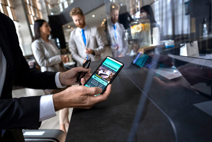 man holding cellphone booking a hotel